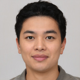 Joyful asian young-adult male with short  black hair and brown eyes