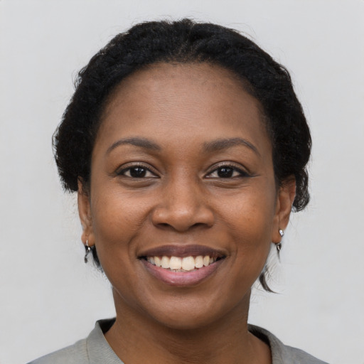 Joyful black young-adult female with medium  black hair and brown eyes