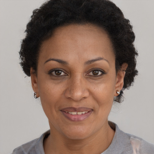 Joyful black adult female with short  black hair and brown eyes