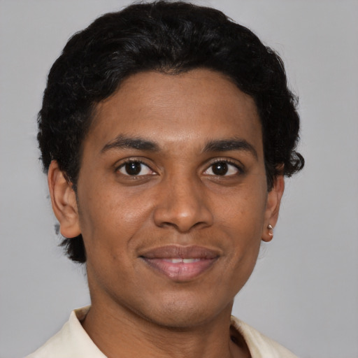Joyful latino young-adult male with short  brown hair and brown eyes