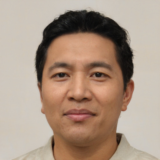 Joyful asian adult male with short  black hair and brown eyes