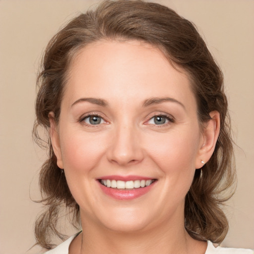 Joyful white young-adult female with medium  brown hair and green eyes