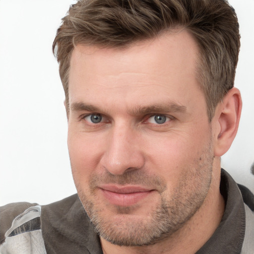 Joyful white adult male with short  brown hair and grey eyes