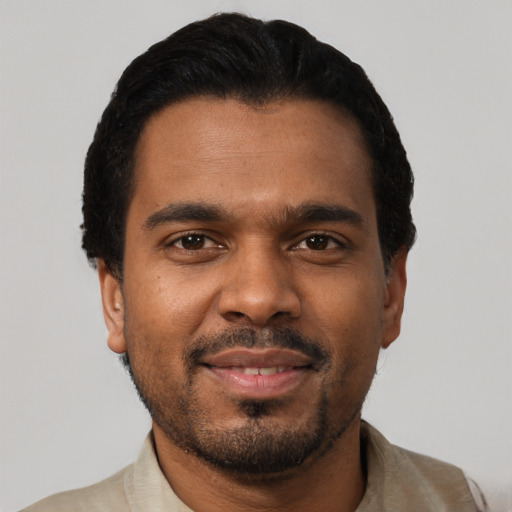 Joyful black young-adult male with short  black hair and brown eyes