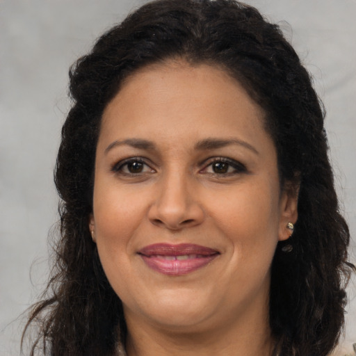 Joyful latino adult female with long  brown hair and brown eyes