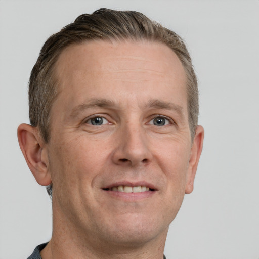 Joyful white adult male with short  brown hair and grey eyes