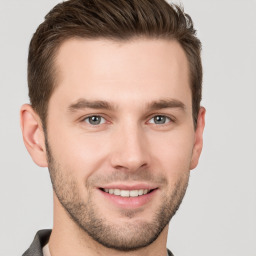 Joyful white young-adult male with short  brown hair and grey eyes