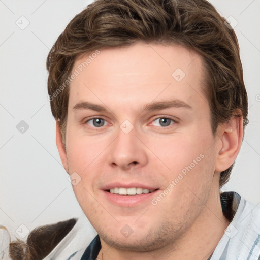 Joyful white young-adult male with short  brown hair and grey eyes