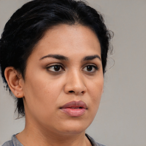 Joyful latino young-adult female with short  black hair and brown eyes