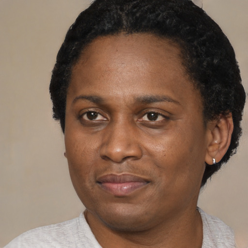 Joyful black adult female with short  black hair and brown eyes