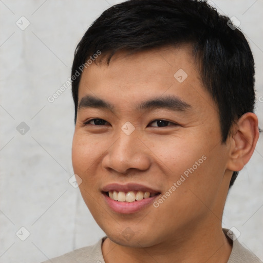 Joyful asian young-adult male with short  brown hair and brown eyes