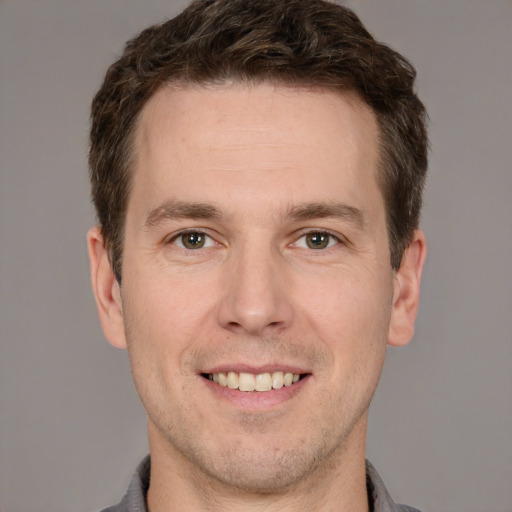 Joyful white adult male with short  brown hair and brown eyes