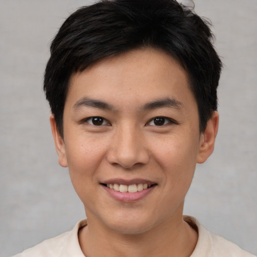 Joyful asian young-adult male with short  brown hair and brown eyes