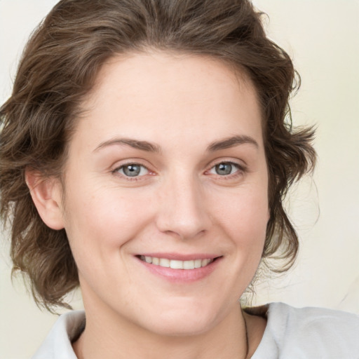 Joyful white young-adult female with medium  brown hair and green eyes