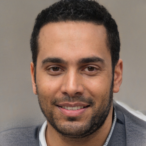 Joyful white young-adult male with short  black hair and brown eyes