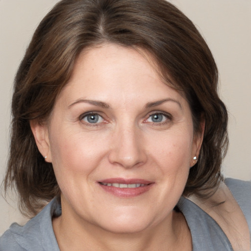 Joyful white adult female with medium  brown hair and grey eyes