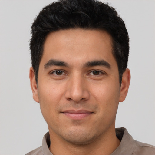 Joyful white young-adult male with short  black hair and brown eyes