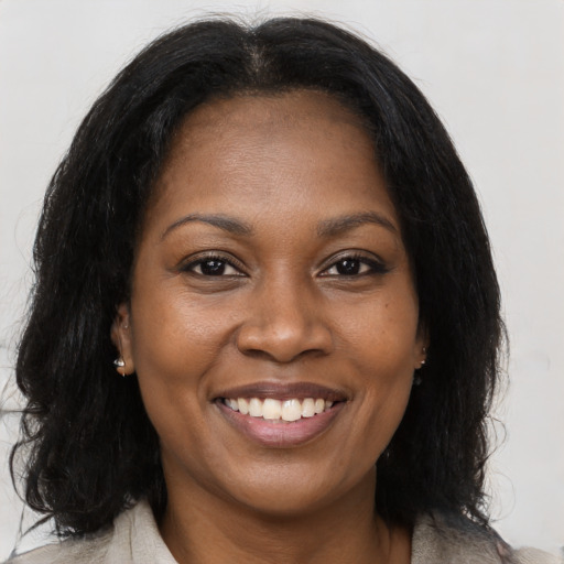 Joyful black adult female with medium  brown hair and brown eyes