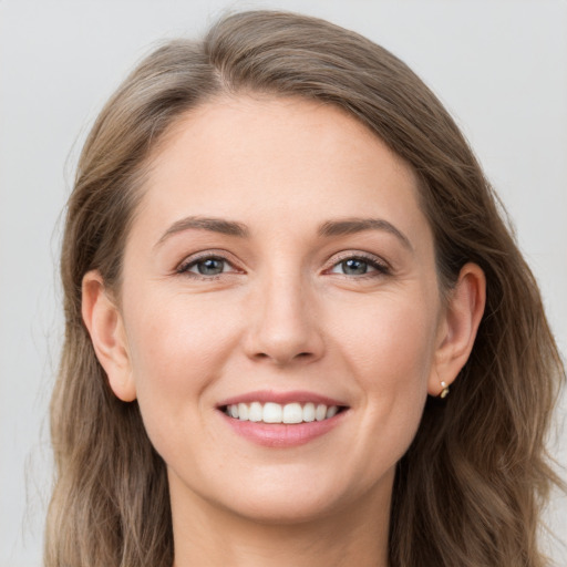 Joyful white young-adult female with long  brown hair and grey eyes