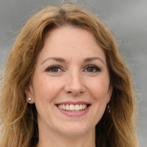 Joyful white young-adult female with long  brown hair and green eyes