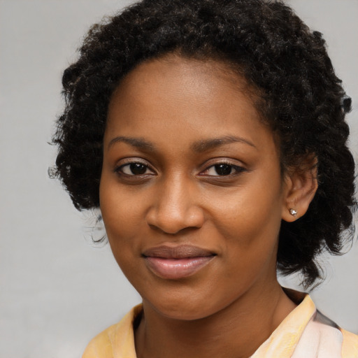 Joyful black young-adult female with long  brown hair and brown eyes