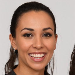 Joyful latino young-adult female with long  brown hair and brown eyes