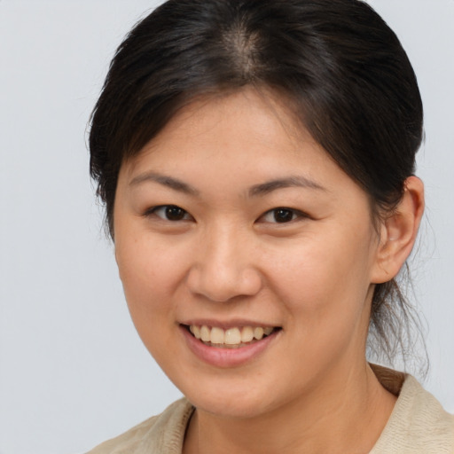 Joyful asian young-adult female with medium  brown hair and brown eyes