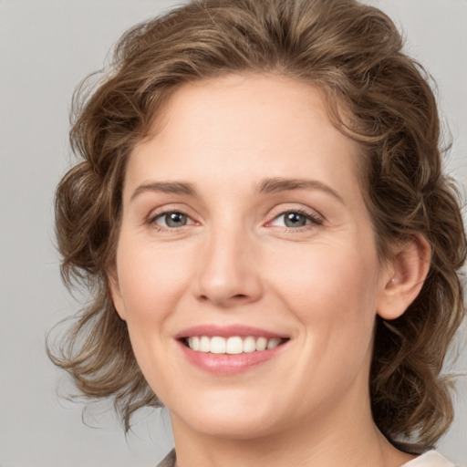 Joyful white young-adult female with medium  brown hair and green eyes