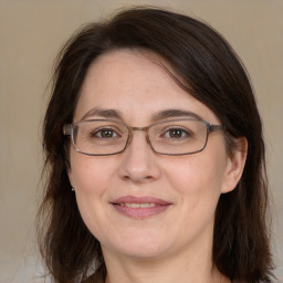 Joyful white adult female with medium  brown hair and grey eyes