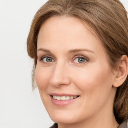 Joyful white young-adult female with medium  brown hair and blue eyes