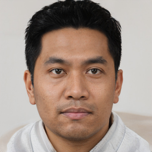 Joyful asian young-adult male with short  black hair and brown eyes