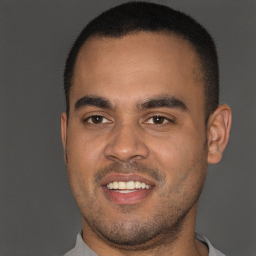 Joyful black young-adult male with short  black hair and brown eyes