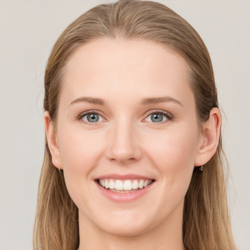 Joyful white young-adult female with long  brown hair and blue eyes