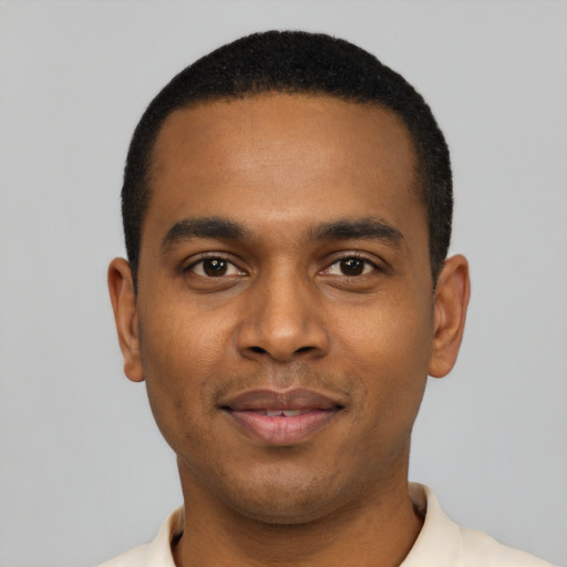 Joyful black young-adult male with short  black hair and brown eyes