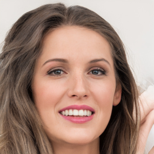 Joyful white young-adult female with long  brown hair and grey eyes