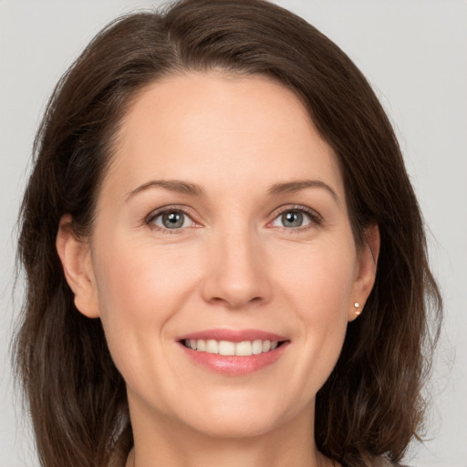 Joyful white young-adult female with medium  brown hair and grey eyes