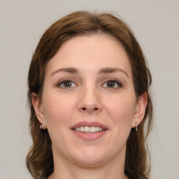 Joyful white young-adult female with medium  brown hair and grey eyes