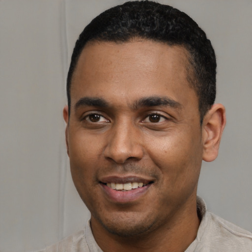 Joyful latino young-adult male with short  black hair and brown eyes