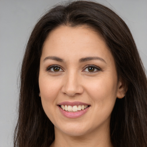 Joyful white young-adult female with long  brown hair and brown eyes