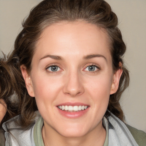 Joyful white young-adult female with medium  brown hair and blue eyes