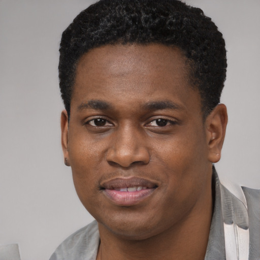 Joyful black young-adult male with short  brown hair and brown eyes