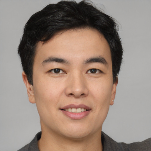 Joyful asian young-adult male with short  brown hair and brown eyes