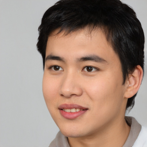 Joyful asian young-adult male with short  brown hair and brown eyes