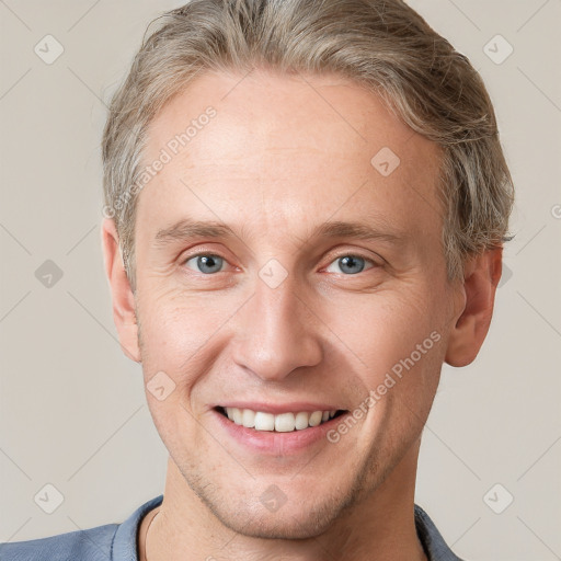 Joyful white adult male with short  brown hair and grey eyes