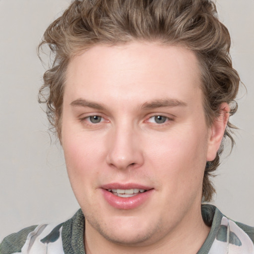 Joyful white young-adult male with medium  brown hair and blue eyes