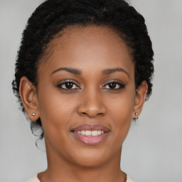 Joyful black young-adult female with short  brown hair and brown eyes