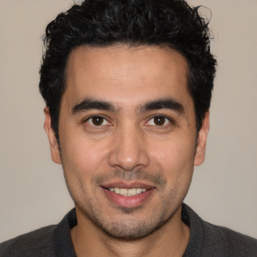Joyful white young-adult male with short  black hair and brown eyes