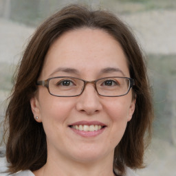 Joyful white adult female with medium  brown hair and blue eyes