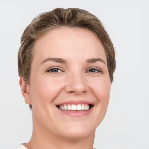 Joyful white young-adult female with short  brown hair and grey eyes