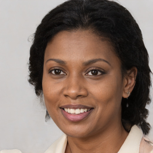 Joyful black young-adult female with medium  brown hair and brown eyes
